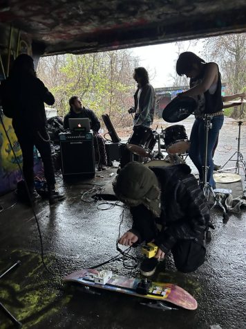 Colten Billings(far left), Liam Sherr(center), Braden Main(above), and Kasey Davolio(far right) in the process of setting up for their second show at Fort Armistead. Billings sets up his bass amp with a member of band Lowlife Tea Party, while Sherr uses a skateboard deck to check the generator and sound on his end.
I really like how were playing shows with these bigger bands that weve seen before and who we love. And theyre always really nice to us; everyone in the scene is supportive, I think mostly because were a new band of teenagers, we get cool points for it, Billings said.