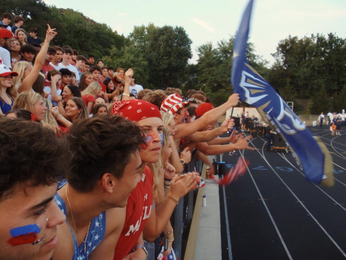 Severna Park students at the USA theme football game against South River 
holding up a Falcons flag after a touchdown.
